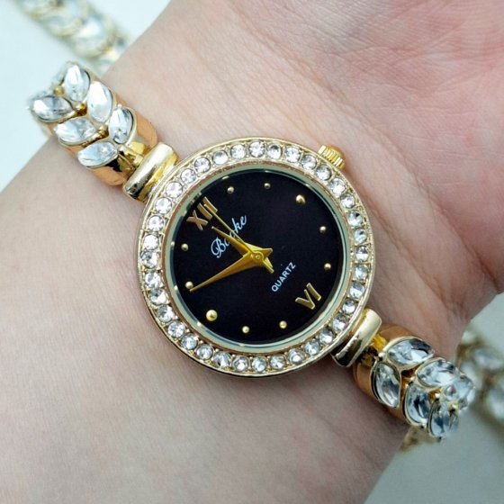 ساعت مچی زنانه نگین دار طرح رویال کرون صفحه مشکی بند طلایی+باطری اضافی کد 2309