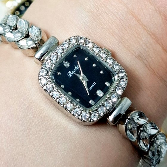 ساعت مچی زنانه نگین دار طرح رویال کرون صفحه مستطیلی مشکی بندنقره ایی+باطری اضافی کد 2314