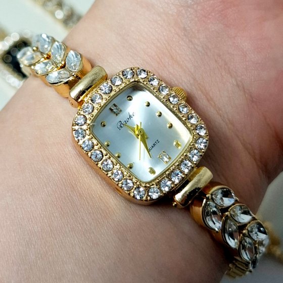 ساعت مچی زنانه نگین دار طرح رویال کرون صفحه مستطیلی سفید بندطلایی+باطری اضافی کد 2317