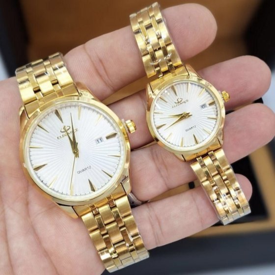 ست ساعت مچی مردانه و زنانه الگانس صفحه سفید بند طلایی+باطری اضافی کد 2557