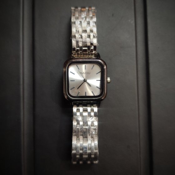 ساعت مچی زنانه نایدو NAIDU بند استیل حصیری نقره ایی-قاب دودی  +باطری اضافی کد 10159